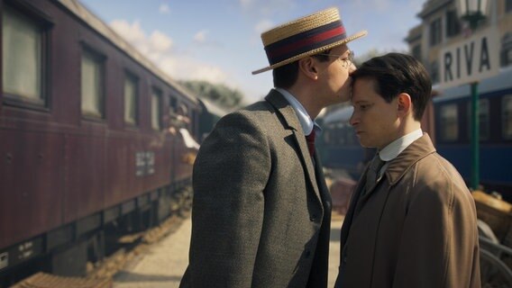 Max Brod (David Kross) küsst Franz Kafka (Joel Basman) an einem Bahnsteig auf die Stirn. © Nicole Albiez 