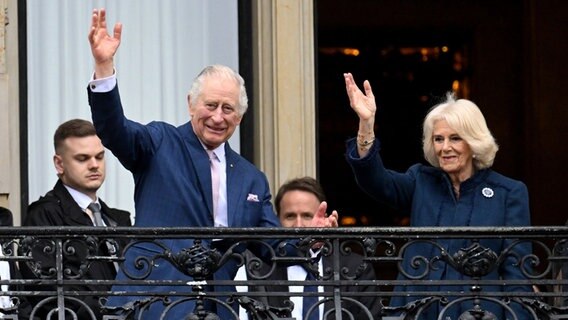 König Charles III. und Camilla stehen auf dem Balkon des Hamburger Rathauses und winken. © Daniel Reinhardt/dpa +++ dpa-Bildfunk +++ Foto: Daniel Reinhardt/dpa