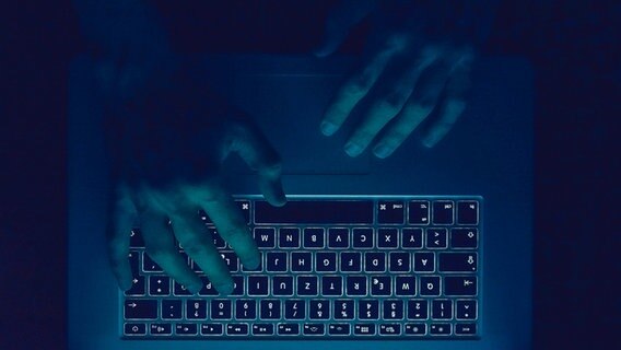 Zwei Hände über einer Tastatur im Dunklen. © Photocase Foto:  PolaRocket