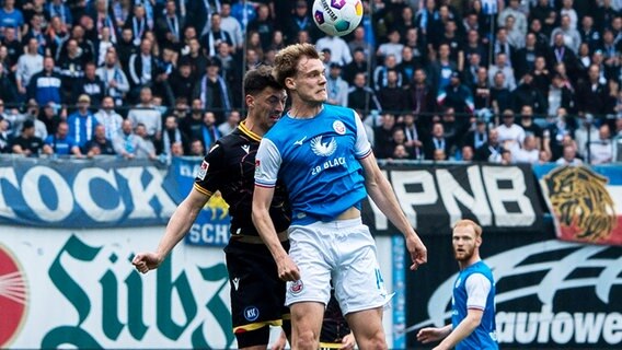Rostocks Svane Ingelsson (r.) und Karlsruhes Nicolai Rapp kämpfen um den Ball. © IMAGO / Ostseephoto 