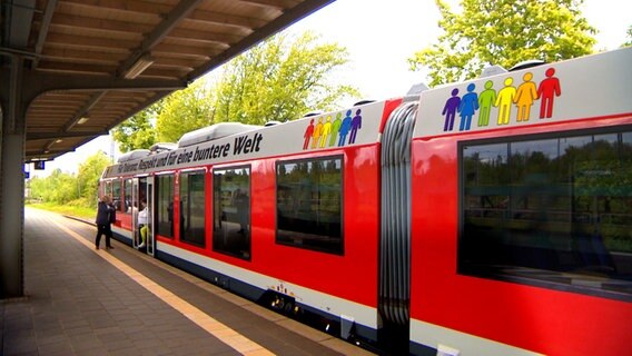 Ein Zug hat eine Aufschrift, die gegen Fremdenfeindlichkeit und Diskriminierung aufruft. © NDR 